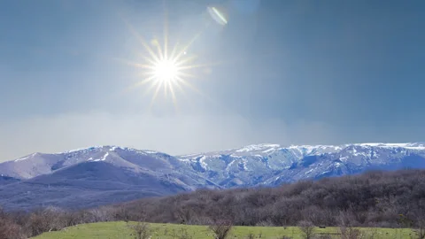 Snowbound mountain ridge under a sparkle sun Stock Footage 258300425