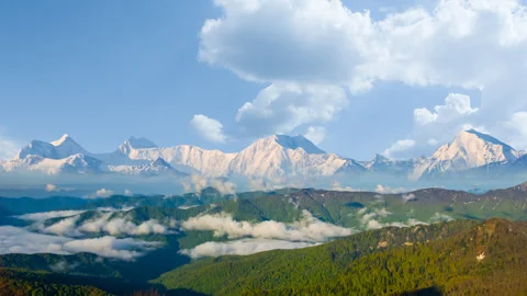 Snowbound mountain valley in dense mist and clouds Stock Footage 257604504
