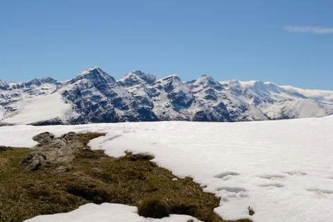 Snowcapped alpine arc in spring Stock Photos