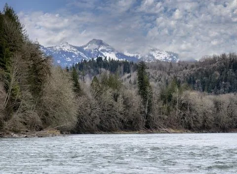 Snowcapped Cascade mountains while wading in Skagit river during spring seaso Stock Photos