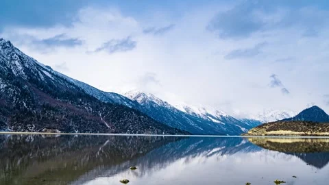 Snowcapped mountain range reflecting in a calm lake in tibet Stock Footage 341938315