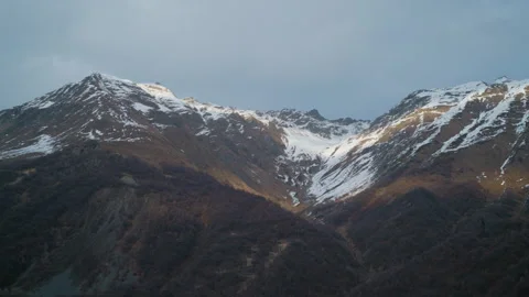 Snowcapped Mountains Rising Majestically Under a Softly Cloudy Sky Filled Stock Footage 302215041