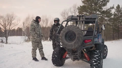 Snowcovered trail with riders ready for action. Two ATV enthusiasts converse and Stock Footage 334785398