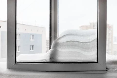 Snowdrift between windowpanes in winter Stock Photos
