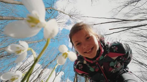 Snowdrops in the forest. spring forest. flowering snowdrops. teenage girl Stock Footage 166926640