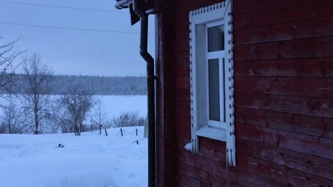 Snowfall against background of window of rural house and country landscape with Stock Footage 232609514