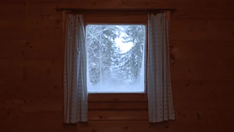 Snowfall and snow-covered trees seen through a small window with curtains. Vidéo 167288644