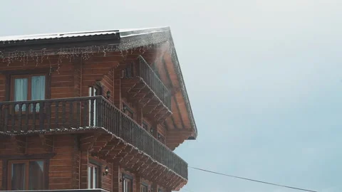 Snowfall and snowflakes flying on the background of wooden house Stock Footage 142552595