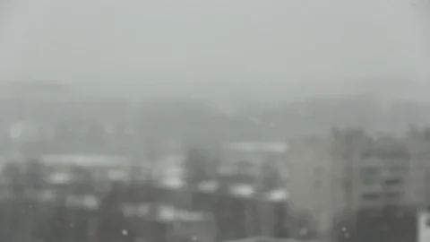 Snowfall on the background of the city. Snow falls from the gray sky, snowflakes Stock Footage 126780029