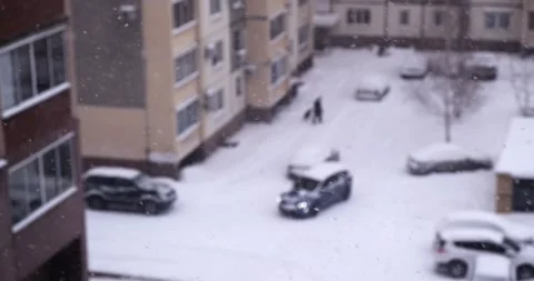 Snowfall on the background of the courtyard of a sleeping urban area Stock Footage 168816235