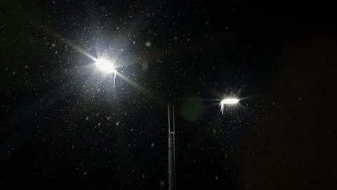 Snowfall on the background of the included modern lanterns on city street. Stock Footage 224454510
