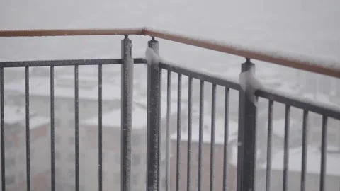 Snowfall on balcony railing creating icicles during winter weather conditions Stock Footage 331900282