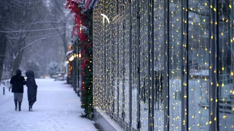Snowfall in the city. Christmas lights on the windows. Slow motion video Stock Footage 224924672