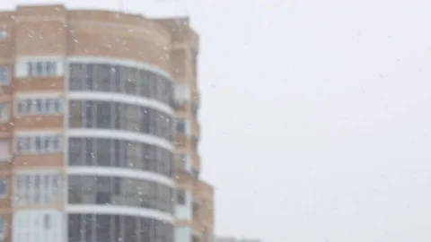 Snowfall in a city. Simple scene - falling snowflakes on a cityscape background. Stock Footage 127894437