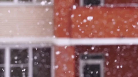 Snowfall in the city. Snowflakes fly in the background of a window on house Видео 71005312