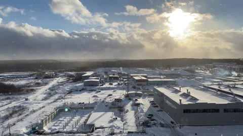 Snowfall on a clear winter or spring day in an industrial area. Video. Soft Stock Footage 150090776