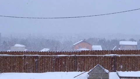 Snowfall in countryside. View from the window of the plot, cottages and forest Stock Footage 153087552