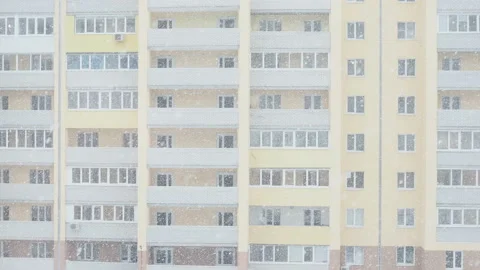 Snowfall in front of a modern new brick apartment building View from the window Vidéo 128880932