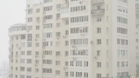 Snowfall in front of a modern new brick apartment building View from the window. Stock Footage 128881627