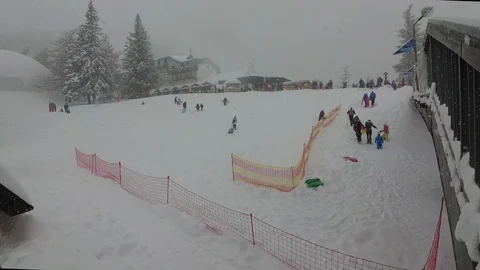Snowfall in the Mountains the Children Go Down the Hill on a Sled Stock Footage 101637823