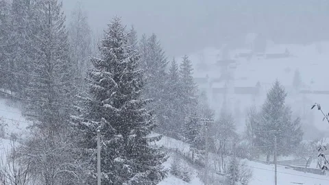 Snowfall in the mountains. Houses in the background. Stock Footage 147689211