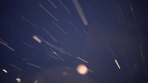 Snowfall in the night falling on lens Stock Footage 128949994