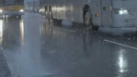 Snowfall over a boulevard with buses in slow motion Stock Footage 328318188