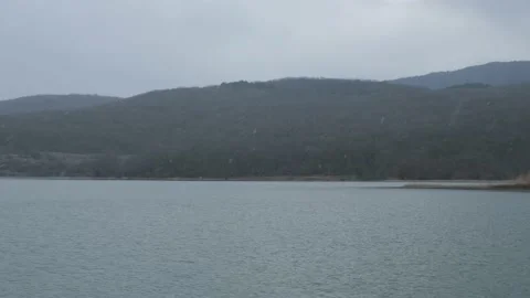 Snowfall over the lake. A cloudy winter day. Video stock 231142446
