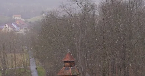 Snowfall over an Old building rooof and in the woods, 4K Stock Footage 84981503