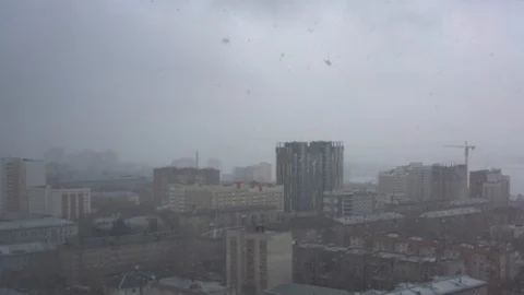 Snowfall on an overcast day against the backdrop of the city. 스톡 동영상 88638173