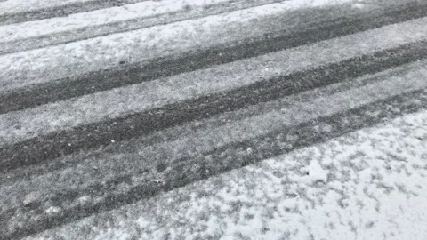 Snowfall on the road which has car tire tracks on the snow Stock Footage 144890830