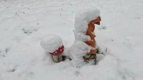Snowfall. Snow flakes covered the decorative gnome Video stock 232412831