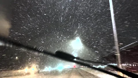 Snowfall through the windshield of a car. Snow falls on the windshield of a car Stock Footage 261222399