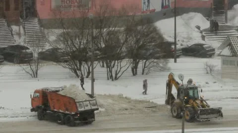 Snowfall, a tractor loads snow in the dump truck Stock Footage 22243741