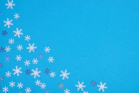 Snowflake confetti on light blue background. Stock-Fotos