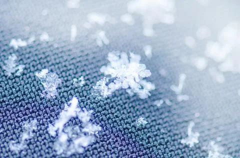 Snowflake glowing on dark texture. 스톡 사진