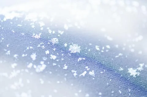 Snowflake glowing on dark texture. Photos