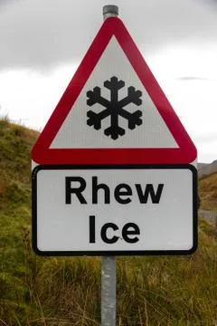 Snowflake ice triangular warning sign, bilingual Rhew, Wales, United kingdom. Stock Photos