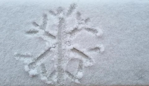 Snowflake shape writing on clear white snow on street, winter begins Stock Photos
