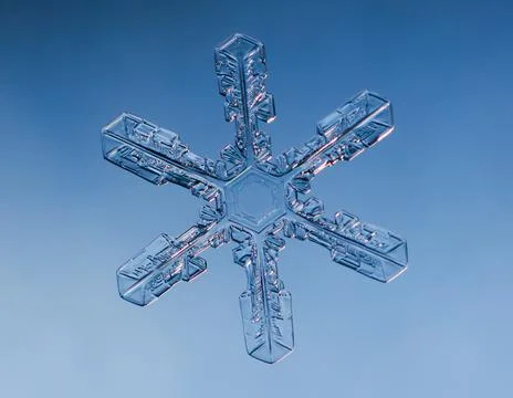 Snowflake on smooth gradient background. Macro photo of real snow crystal on 스톡 사진