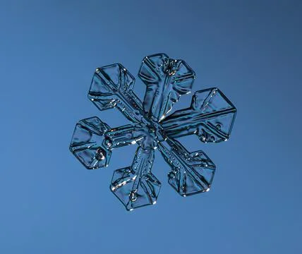Snowflake on smooth gradient background. Macro photo of real snow crystal on 스톡 사진