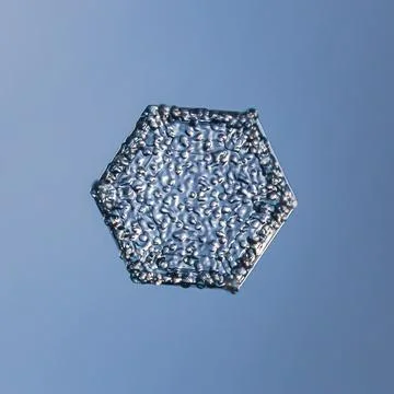 Snowflake on smooth gradient background. Macro photo of real snow crystal on Stock Photos