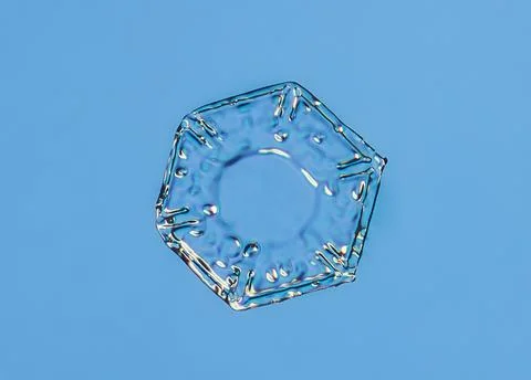 Snowflake on smooth gradient background. Macro photo of real snow crystal on 스톡 사진