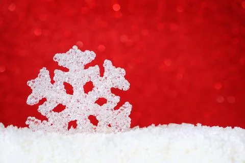Snowflake in snow on red background with copy space Stock Photos