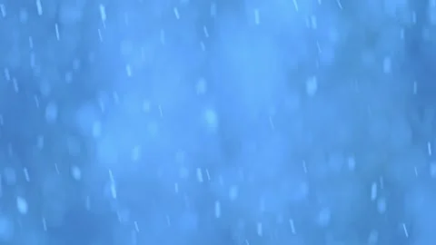 Snowflakes dancing in slow motion, creating a magical winter bokeh on a blue Stock Footage 295371907
