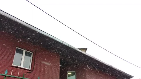 Snowflakes drifting down on a quiet winter day at a brick building Stock Footage 302564774