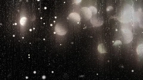Snowflakes falling against dark window glass with soft blurred golden bokeh Stock Footage 342120080