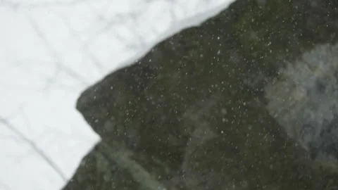 Snowflakes Falling in Front of Rocks Stock Footage 330973841