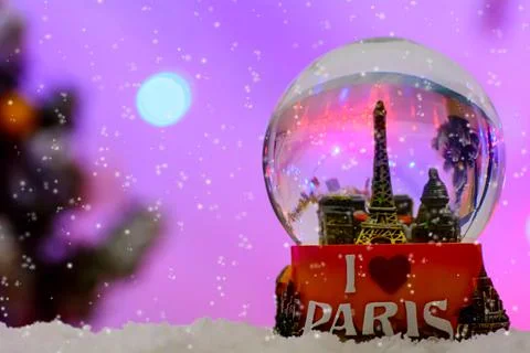 The snowflakes falling over a Paris Eiffel Tower Snow Globe Souvenir on a blurre Fotos Stock
