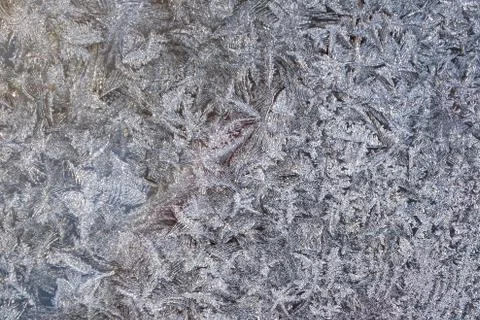 Snowflakes ice pattern with sunlight on winter window glass Stock Photos